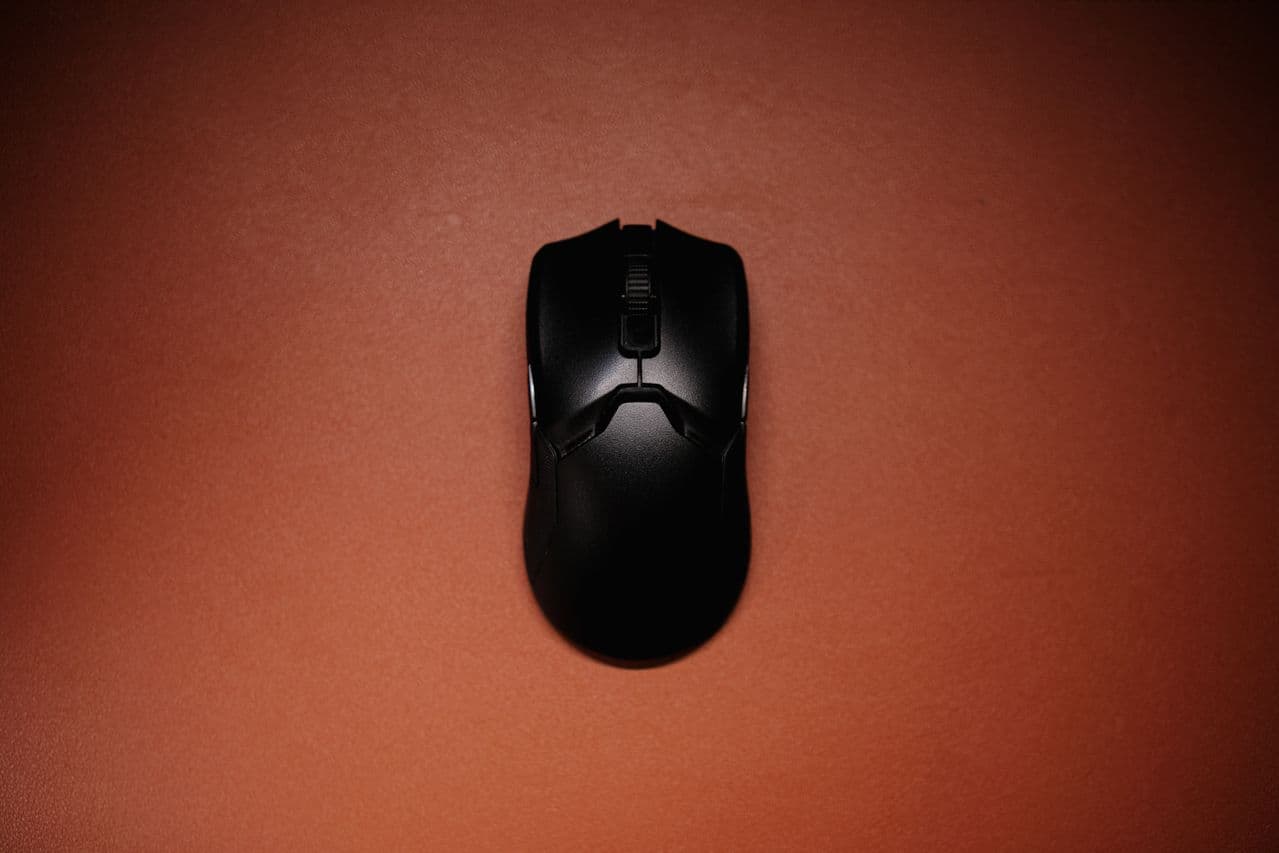 Top-down view of a sleek black gaming mouse on a desk