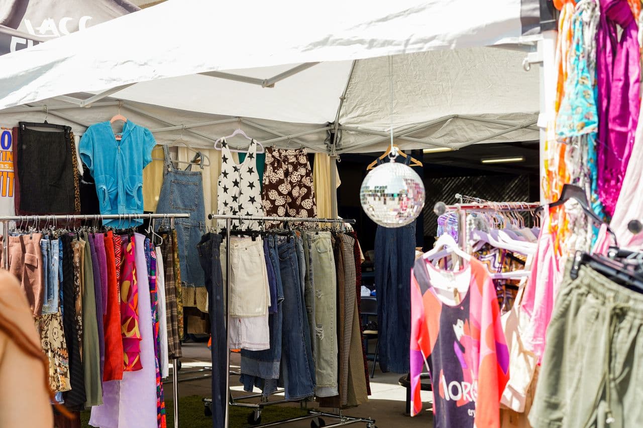 Vibrant outdoor pop-up clothing bazaar with racks of clothes on display