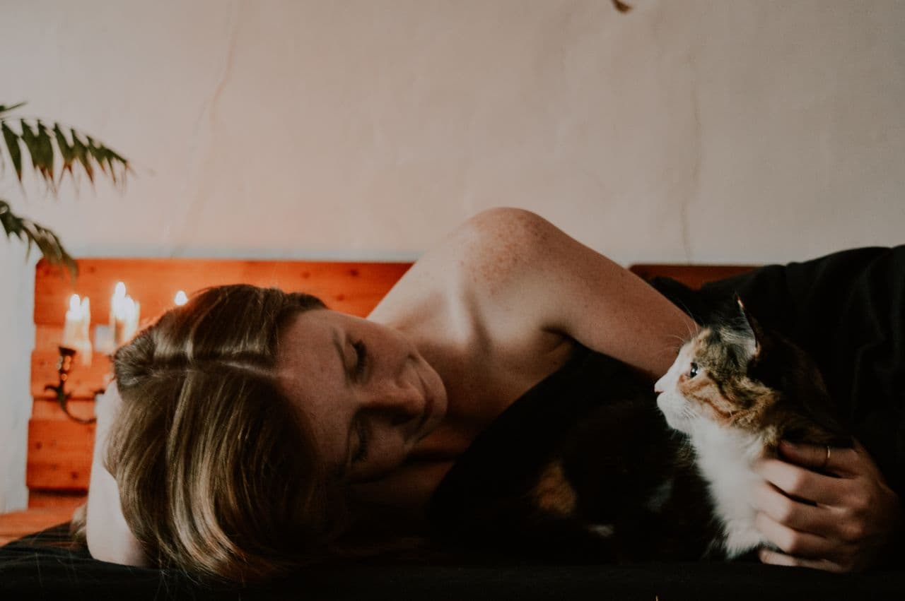 Woman spending time with her pet cat indoors