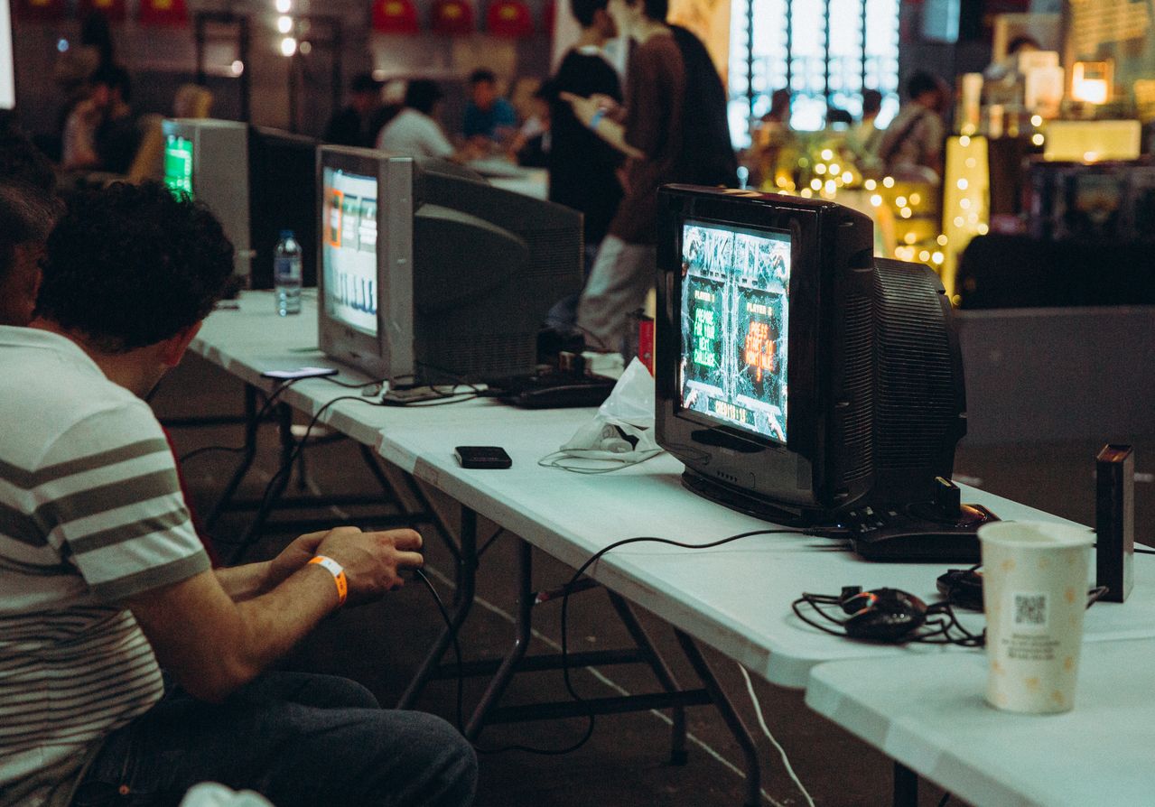 A group of adults playing video games together on a couch