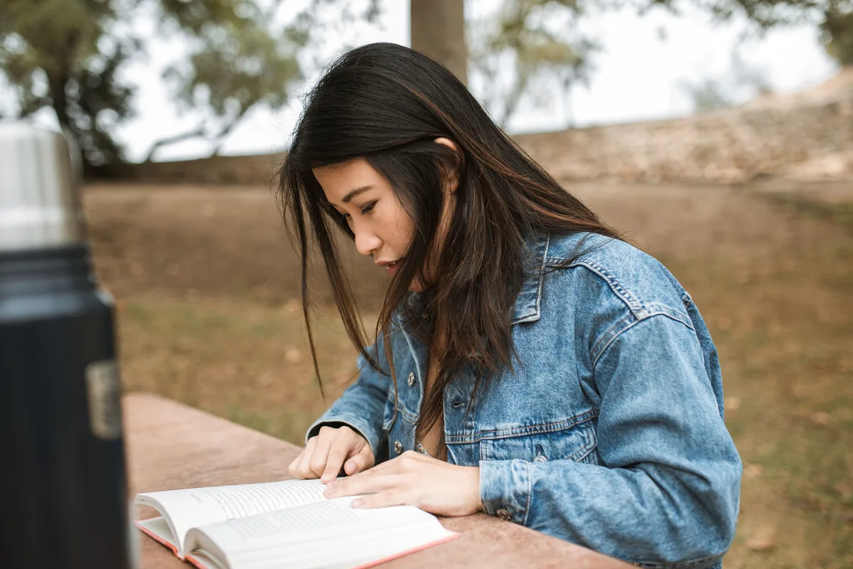 Woman reading a book, building vocabulary through regular reading